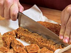 a person cutting up food on top of a wooden table