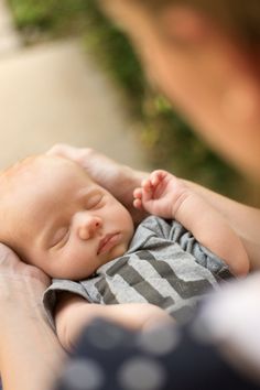 a woman holding a sleeping baby in her arms