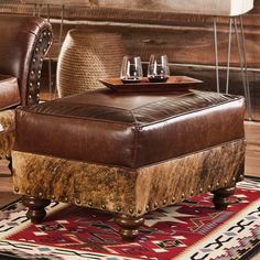 a brown leather ottoman sitting on top of a rug