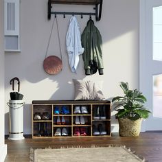 an entryway with shoes, plants and coat rack on the wall next to it