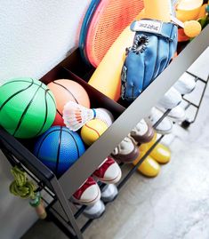 a rack with basketballs, tennis balls and other sports equipment on it's sides