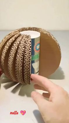 a hand is holding a roll of brown paper and it's wrapped in twine