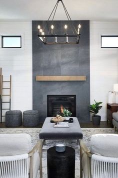 a living room filled with furniture and a fire place under a chandelier above a fireplace