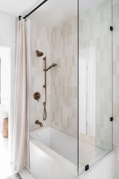 a bathroom with a bathtub, shower head and towel hanging on the wall next to it