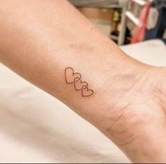 a person's arm with two hearts tattoo on it