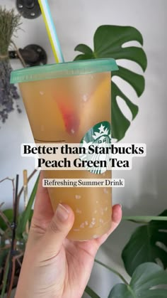 a person holding up a drink with the words better than starbuckss peach green tea