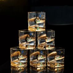 several glasses are stacked on top of each other in front of a black background with gold trimmings