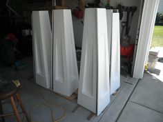 three tall white doors sitting in a garage