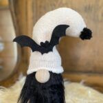 a black and white stuffed animal with a bat on it's head