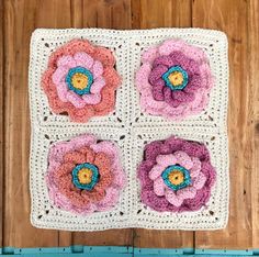 a crocheted square with four flowers on it