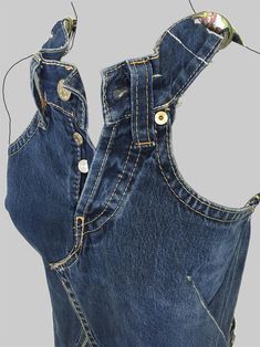 an old pair of blue jeans with holes in the back and side pockets that have buttons on them