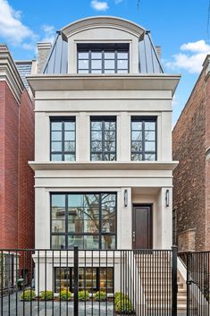 a two story house with black iron railings