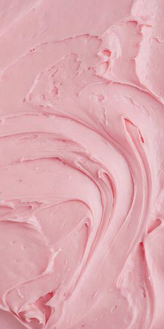 a close up view of pink icing on a cake