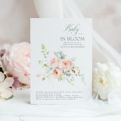 a baby in bloom card next to flowers