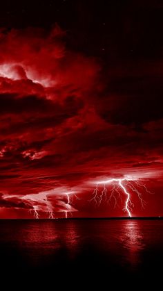 red clouds and lightning over the ocean at night