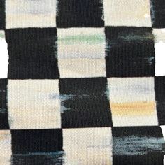 a black and white checkered fabric is shown with some paint on it's edges