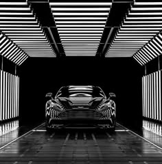 a black and white photo of a car in a parking garage with lights on the ceiling