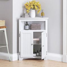 a white cabinet with yellow flowers and towels