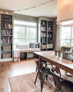 a living room filled with lots of furniture and bookshelves next to a window