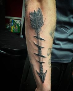 a man's arm with three feathers on it