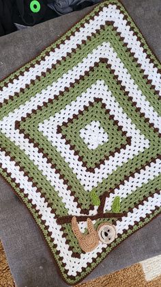 there is a crocheted blanket on the floor with a slotty in it