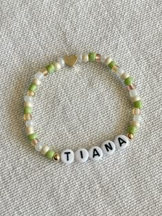 a beaded bracelet with the word mama spelled in white and green beads on it