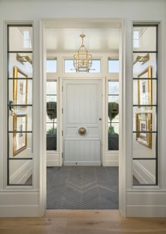 an instagramted photo of a white door and chandelier