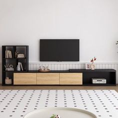 a flat screen tv sitting on top of a wooden entertainment center next to a white wall