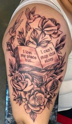 a woman's arm with roses and an open book tattooed on the back of her shoulder