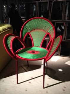 a green and red chair sitting on top of a wooden floor