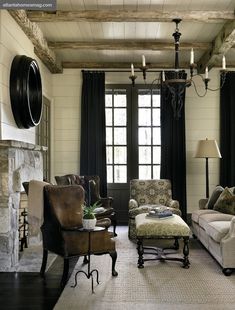 a living room with couches, chairs and a chandelier hanging from the ceiling