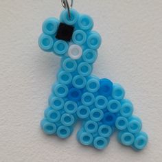 a blue dog shaped beaded keychain on a white surface