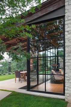 an open patio with glass walls and sliding doors leading to the outside dining room area