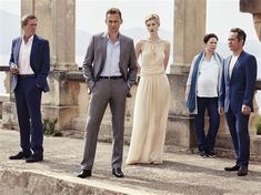 four men and two women standing in front of an old building with columns on the side