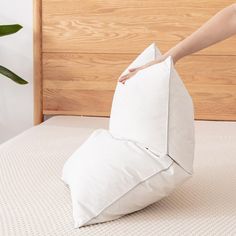 someone is placing an origami pillow on the bed