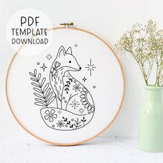 an embroidery pattern with a fox sitting on the ground next to a vase filled with baby's breath flowers