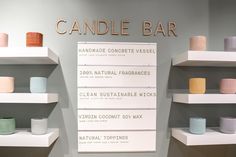 there are many candles on the shelves in this display case that is labeled candle bar