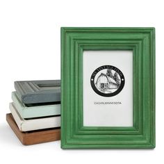 three different colored frames sitting next to each other on a white surface, one with a green frame and the other has an image of a bridge