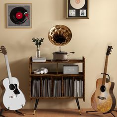 three guitars are sitting on the floor in front of a record player and recordshelf