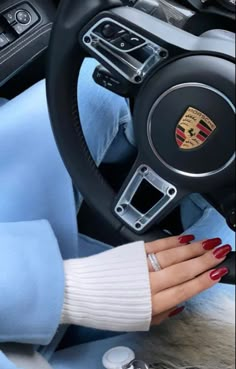 a woman's hand on the steering wheel of a car