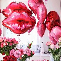 pink flowers and red balloons are in vases on the table with lipstick - shaped balloons