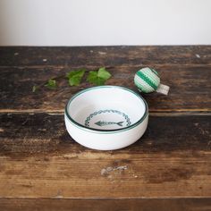 two white bowls sitting on top of a wooden table next to an easter egg decoration