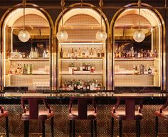 the bar is lined up with stools and bottles