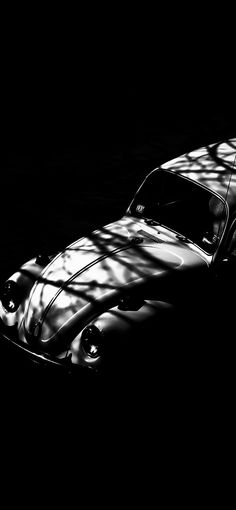 a black and white photo of a car parked in the dark with its hood up