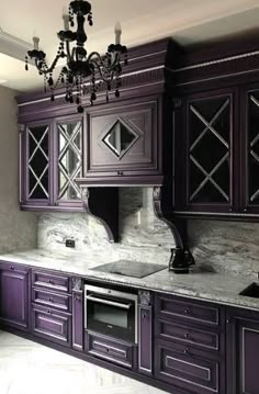 an elegant kitchen with purple cabinets and marble counter tops, chandelier above the stove