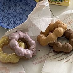 three donuts sitting on top of a table next to a box of doughnuts