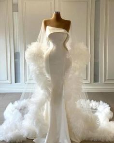 a white wedding dress with feathers on the bottom and one layer of fabric at the back