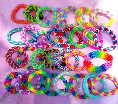 there are many different colored bracelets on the table