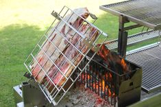 the meat is being cooked on the grill in the yard with it's tongs sticking out