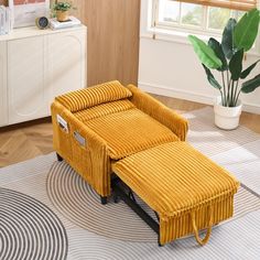 a yellow recliner sitting on top of a rug next to a potted plant